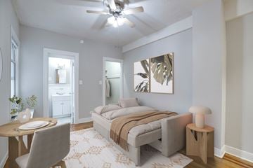 Washington apartment for rent - A bedroom with a bed, a table, and a ceiling fan.