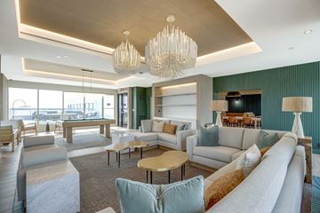 Arlington apartment for rent - A large, modern living room with a long white sofa and a wooden coffee table.