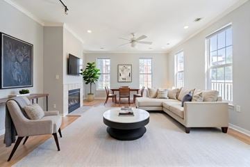 Rockville apartment for rent - A living room with a grey sofa, a grey armchair, a coffee table and a television.