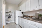 Washington apartment for rent - A kitchen with white cabinets and a granite countertop.