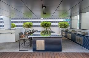 Miami apartment for rent - A modern outdoor kitchen with a bar and chairs.