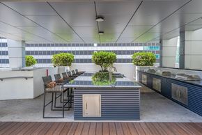 Miami apartment for rent - A modern outdoor kitchen with a wooden floor and a bar area.