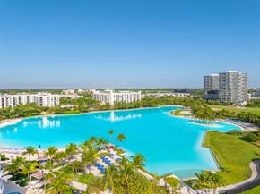 North Miami apartment for rent - A large swimming pool surrounded by palm trees and a resort.
