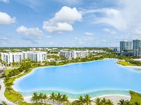 North Miami apartment for rent - A large swimming pool surrounded by palm trees and buildings.