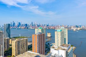 Jersey City apartment for rent - A cityscape with a body of water in the foreground.