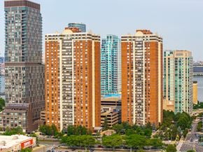 Jersey City apartment for rent - A cityscape with tall buildings and a clear sky.