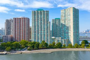 Jersey City apartment for rent - A cityscape with buildings and a body of water in the foreground.