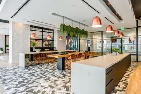 Miami apartment for rent - A modern kitchen with a long island and a dining table with chairs.