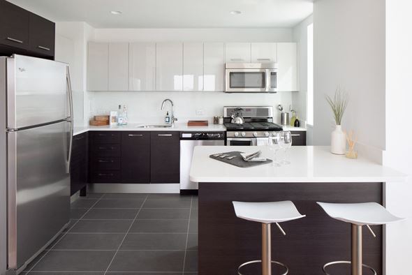 Jersey City apartment for rent - a modern kitchen with stainless steel appliances and a white counter top