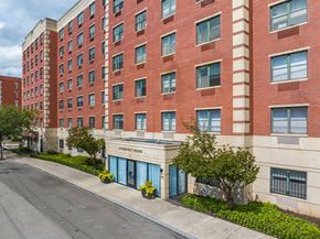 Jersey City apartment for rent - A red brick building with a tree in front of it.
