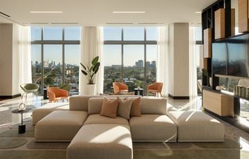 Miami apartment for rent - A living room with a large sectional sofa and a view of the city.
