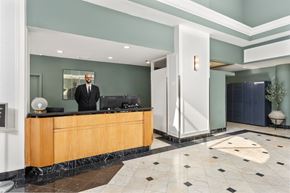 Jersey City apartment for rent - A man in a suit stands behind a reception desk.