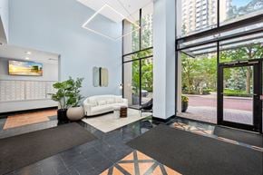 Jersey City apartment for rent - A white sofa sits in a room with a glass door leading to a balcony.