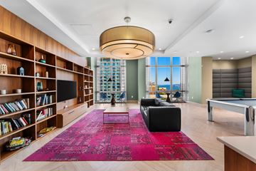 Jersey City apartment for rent - A living room with a pink rug and a television.