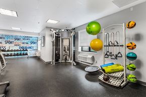 Jersey City apartment for rent - A gym with a variety of equipment and a wall covered in fitness related words.