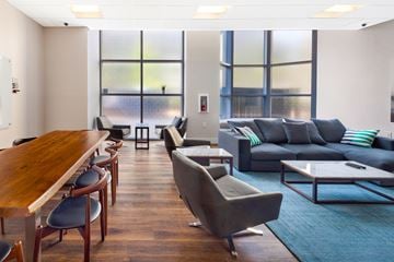 Jersey City apartment for rent - A living room with a grey couch and a wooden table.