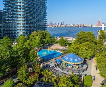 Jersey City apartment for rent - A view of a city from a high vantage point with a pool and a carousel.