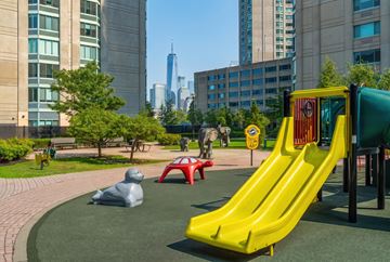 Jersey City apartment for rent - A playground with a yellow slide and a red and yellow ball pit.