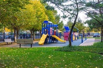 Jersey City apartment for rent - A playground with a yellow slide and a blue structure.