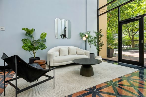 Jersey City apartment for rent - A living room with a white couch, a black chair, and a round table.