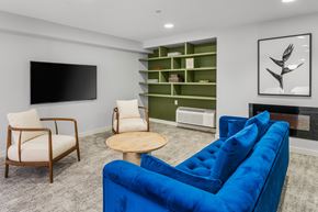 Jersey City apartment for rent - A living room with a blue couch, a wooden table, and a television.