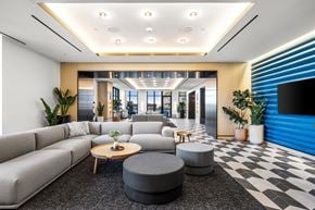 Jersey City apartment for rent - A modern living room with a grey sofa, a wooden coffee table, and a black and white checkered floor.