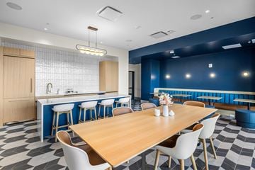 Jersey City apartment for rent - A modern dining room with a wooden table and white chairs.