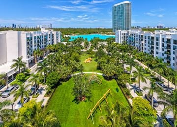 North Miami apartment for rent - A view of a resort with a pool and palm trees.