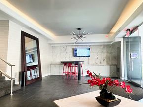 Washington apartment for rent - A modern living room with a wooden table and a vase of red flowers. at 2400 Pennsylvania Avenue Apartments, Washington, DC,20037