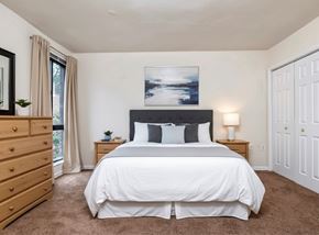 Washington apartment for rent - A bedroom with a large bed and a painting above it.
