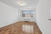 Washington apartment for rent - A room with wooden flooring and a window overlooking a building.