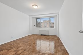 Washington apartment for rent - A room with wooden flooring and a window overlooking a building.