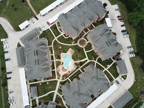 Victoria apartment for rent - A bird's eye view of a residential area with houses and a swimming pool.