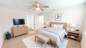 Victoria townhouse for rent - A bedroom with a bed, dresser, and tv.