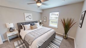 Victoria apartment for rent - A bedroom with a bed, nightstand, and a plant.