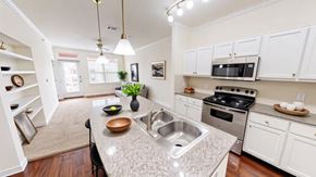 Victoria apartment for rent - A kitchen with white cabinets and a granite countertop.
