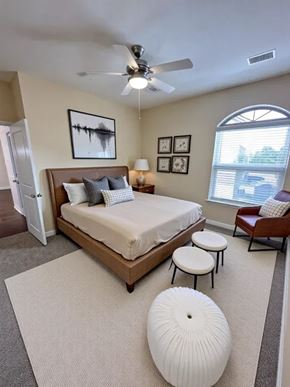 Victoria apartment for rent - A bedroom with a bed, a chair, and a ceiling fan.