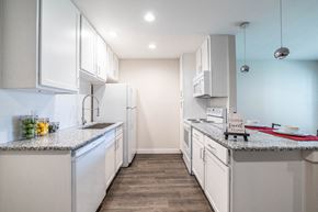 Victoria apartment for rent - A kitchen with white cabinets and a granite countertop.