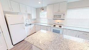 Victoria townhouse for rent - A kitchen with white cabinets and appliances.