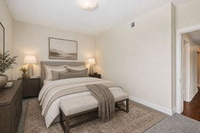 Kansas City apartment for rent - A bedroom with a large bed and a painting on the wall.