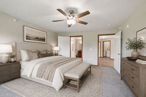 West Chanhassen apartment for rent - A bedroom with a large bed and a ceiling fan.