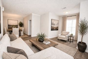 Snellville apartment for rent - A living room with a white couch, a coffee table, and a painting on the wall.