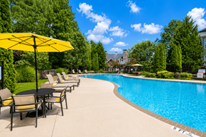 Snellville apartment for rent - A pool with a yellow umbrella and chairs around it.