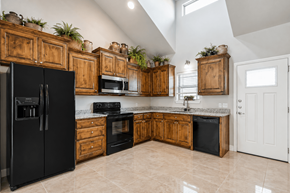 Granbury apartment for rent - A kitchen with black appliances and wooden cabinets.