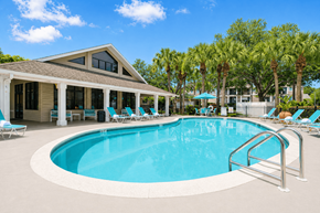 Naples apartment for rent - A swimming pool with a metal railing and a house with a brown roof.