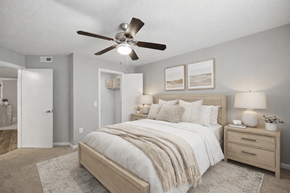 Mooresville apartment for rent - A bedroom with a bed, nightstand, and a ceiling fan.