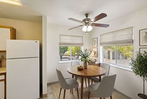 Cedar City apartment for rent - A dining room with a white refrigerator and a round wooden table with four grey chairs.