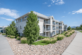 Bluffdale townhouse for rent - A modern apartment complex with a gravel driveway in front.