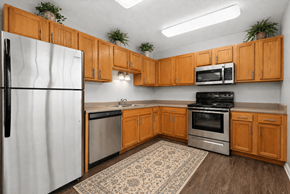 West Jordan apartment for rent - A kitchen with wooden cabinets and a white refrigerator.