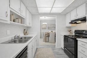 Stone Mountain apartment for rent - A kitchen with white cabinets and a black stove top oven.